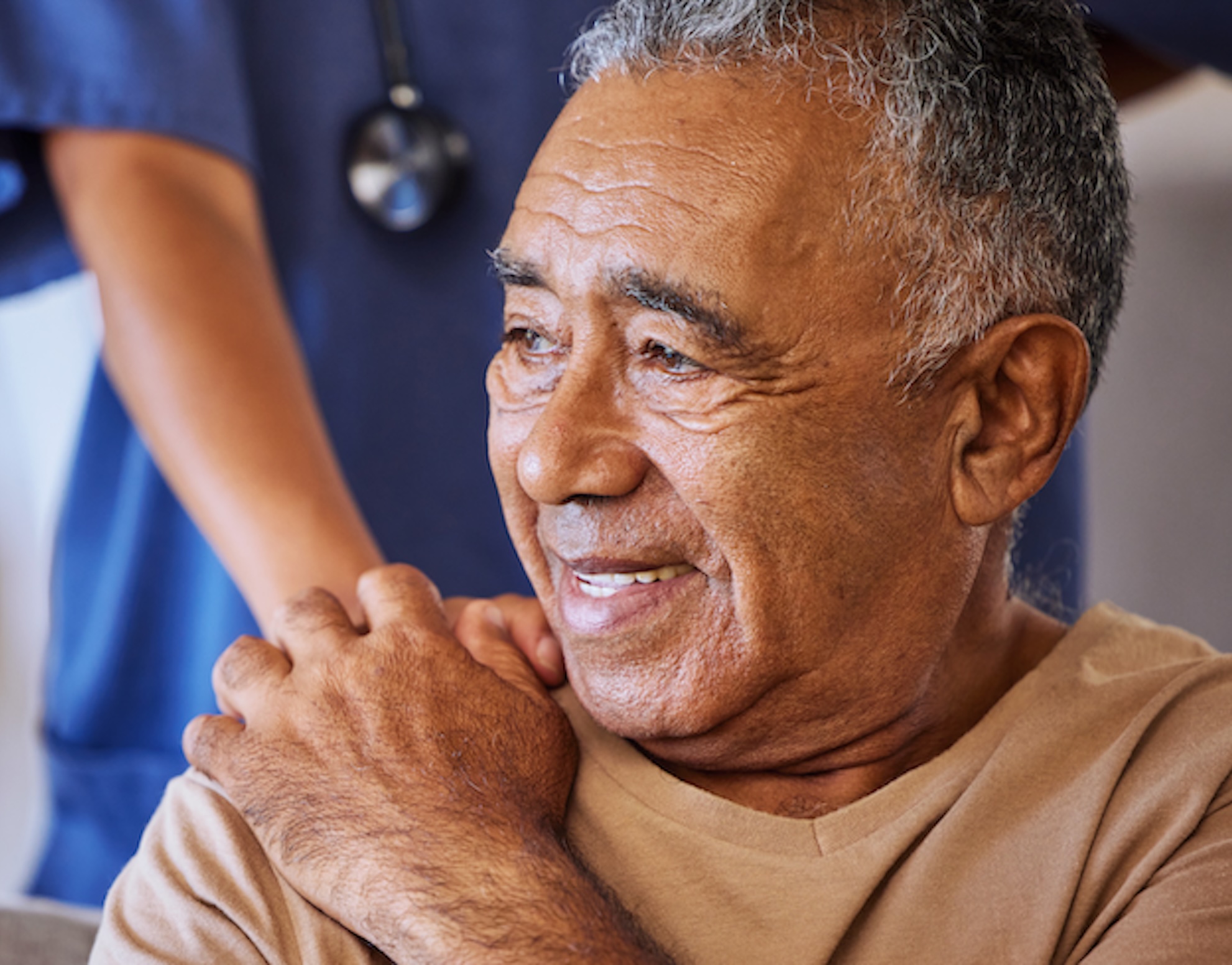 Cancer patient holding hand of nurse and smiling